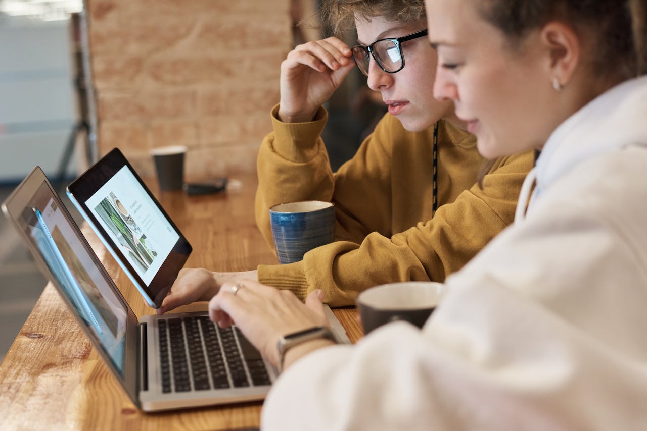 Deux personnes relisent un site sur ordinateur et tablette avant sa refonte